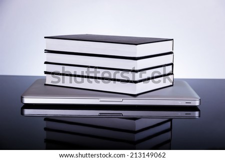 Back to school concept, laptop books on reflective surface