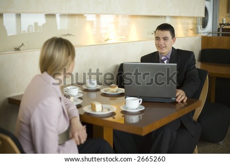 Couple of People at the Cofe Table with Laptop. Short Depth of Focus (On Man\'s Face).