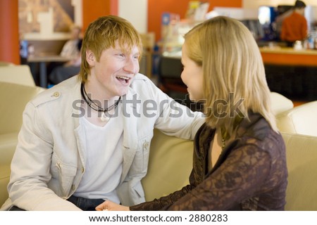 Man and woman are sitting at Cafe and having conversation. Short depth of focus on man\'s face.