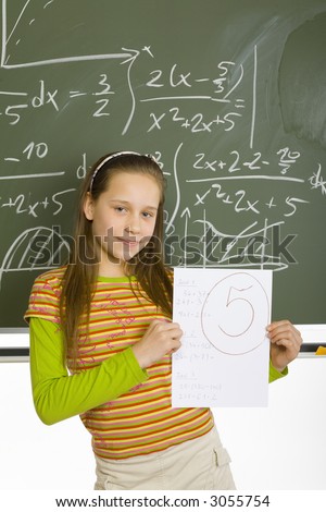 13yo girl are standing and looking at camera. She\'s holding top marked test. Behind her there\'s greenboard with maths.