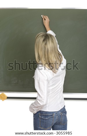 Woman (teachear) are standing with chalk in hand close to greenboard. She\'s starting to write. Back view. Focus on board/hand.