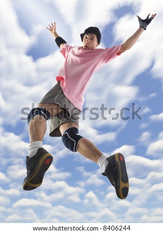 Young surprised and looks like falling bboy in cap. Looking at camera.  Unusual angle view - directly below. Whole body.