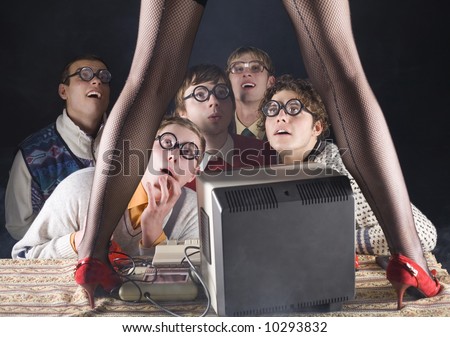 Five nerdy guys sitting in front of old-fashioned computer and stripteaser. They are looking fascinated. Front view