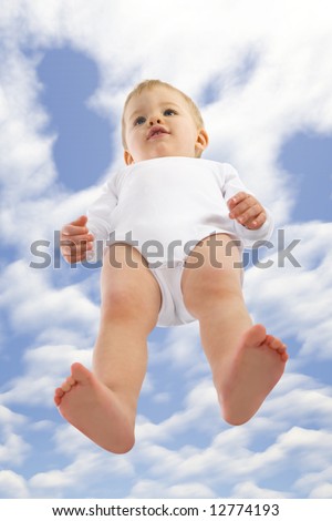 Baby boy standing. Cloudy sky above him. Unusual angle view - directly below.