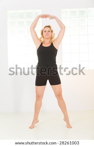 Elder woman dressed sportswear working out. She\'s looking at camera. Front view.