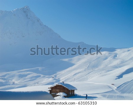 Mountain cabin on sunny day. Extensive powder snow. French alps