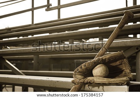 High school baseball practice with ball in glove and bat on bleachers.