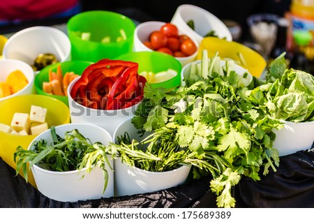 Salad ingredients with lettuce, tomatoes, cucumbers, and cheese.