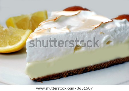 Lemon meringue pie with lemons in background.