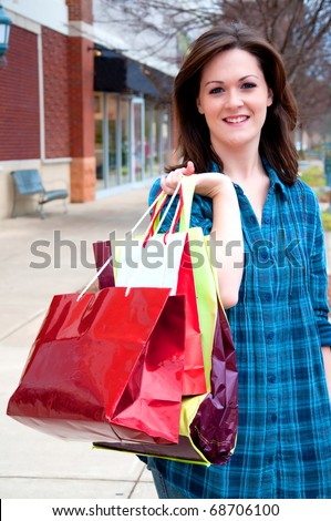 Attractive young female holding shopping bags while on shopping spree.