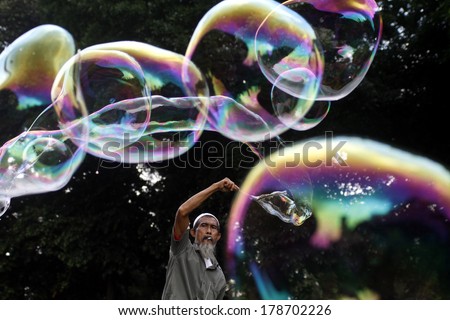 A soap bubble vendor attracts customers at a street market on January 26, 2014 in Jakarta, Indonesia.