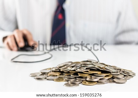 Pile of coins with hand on computer mouse, businessman can manage personal finance directly and promptly