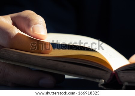 Closeup finger on the old book for reading concept