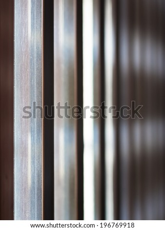 Abstract steel background, closeup on steel fence in a row with shallow depth of field