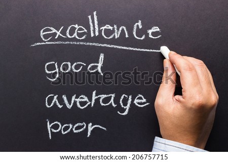 Hand underline Excellence word on audit with chalk