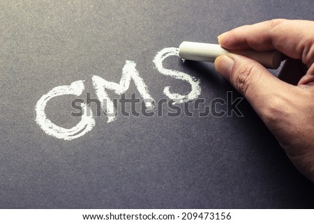 Hand writing CMS abbreviation (content management system) with chalk