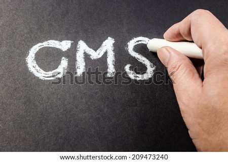 Hand writing CMS abbreviation (content management system) with chalk