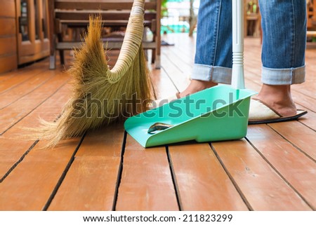 Sweeping dust on wood floor, closeup   broomstick and dust pan