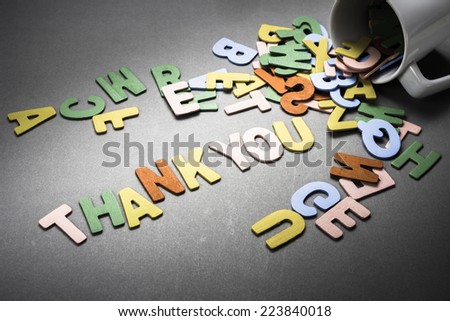 Wood letters spill out of the cup as Thank you word