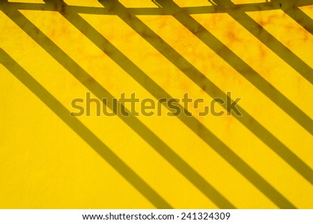 Abstract building, yellow concrete wall with shadow lines