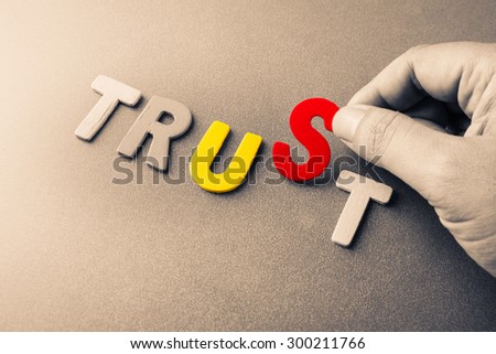 Trust Us, hand arrange wood letters as Trust word with color letters of Us word inside