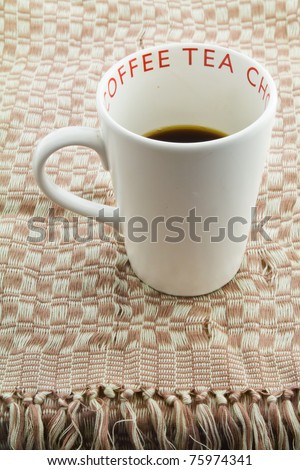 Coffee cup on handmade weaved brown fabric