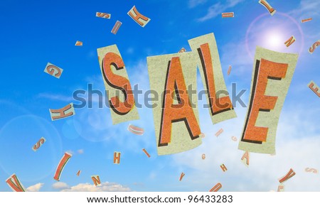 Sale word on pieces of paper blowing in blue sky