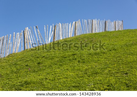 Wooden fence on a grass covered hill
