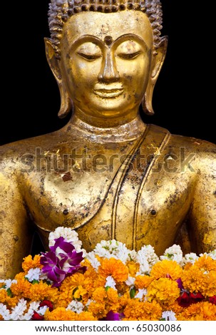 a buddhist statue with garland isolated on black background, Thailand