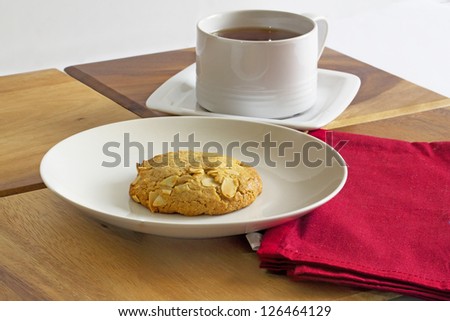 Cup of black tea and a peanut butter biscuits with almond topping
