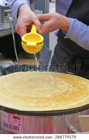 ALTRINCHAM, UK - JUNE 7 2015: A demonstration of the making of a lemon and sugar crepe at Altrincham market, Manchester. Altrincham is in Trafford, Greater Manchester and an affluent commuter town