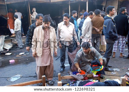 KARACHI, PAKISTAN - DEC 24: Shopkeepers gather at site after fire eruption due to electric short circuit short circuit in cabin shops at Hyderi Market, on December 24, 2012 in Karachi.