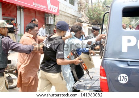 KARACHI, PAKISTAN - JUN 12: Police officials arresting a member of New Appointment  Teachers Action Committee during a protest demonstration near Sindh Assembly on June 12, 2013 in Karachi.