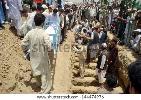 QUETTA, PAKISTAN - JUL 01: Shiite mourners Bury dead bodies of suicide bomb blast  victims of Aliabad area of Hazara town after their funeral prayer at graveyard on July 01, 2013 in Quetta.