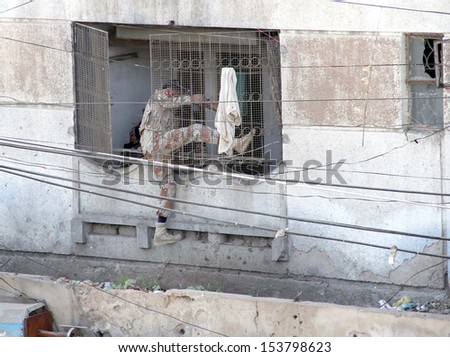 KARACHI, PAKISTAN - SEP 11: Security cordon off residential complex during  targeted serch operation against criminal and arrested a numbers of suspected persons, on September 11, 2013 in Karachi.