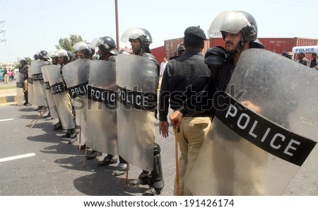 KARACHI, PAKISTAN - MAY 07: Police officials are standing alert to disperse rally of  underpaid teachers moving ahead towards Bilawal House, on May 07, 2014 in Karachi.