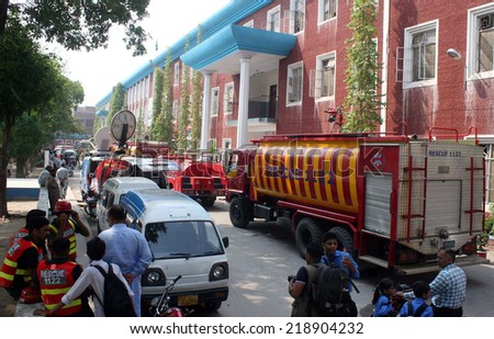 LAHORE, PAKISTAN - SEP 22: Fire fighters busy in extinguishing fire at Election Commission of Pakistan (ECP) building basement that caught fire due to unknown reason, on September 22, 2014 in Lahore.