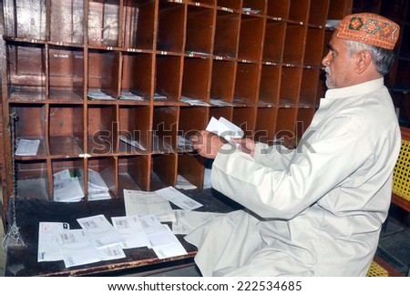 QUETTA, PAKISTAN - OCT 09: Postman is busy in his work in a post on the occasion of World Post Day at Post office building on October 09, 2014 in Quetta.