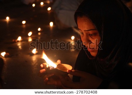KARACHI, PAKISTAN - MAY 15: Muslim League-Q are lightening earthen lamp during a demonstration against massacre of people belong to Ismaili Community on  May 15, 2015 in Karachi.