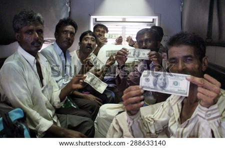 KARACHI, PAKISTAN - JUN 18: Released fishermen are showing Dollar bills given by  Pakistani authorities as travel expenses, at Cantt Station on June 18, 2015 in Karachi.