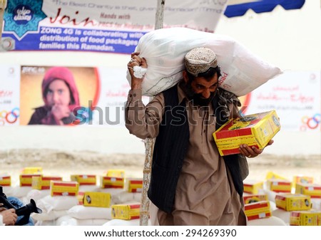 QUETTA, PAKISTAN - JUL 07: Volunteers distribute relief goods among needy people during distribution ceremony ahead of Eid arranged by Pakistan Red Crescent Society on July 07, 2015 in Quetta.