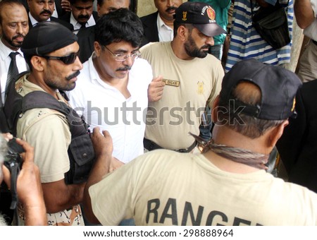 KARACHI, PAKISTAN - JUL 22: (MQM) leader Qamar Mansoor is being escorted by security staffs as he has been send on Judicial Remand for 90 days by Anti Terrorism Court on July 22, 2015 in Karachi.