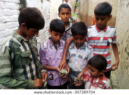 SIALKOT, PAKISTAN - AUG 18: innocent children are showing the shells of Indian mortar shells fired during today\'s unprovoked intensified heavy shelling by the Indian BSF on August 18, 2015 in Sialkot.