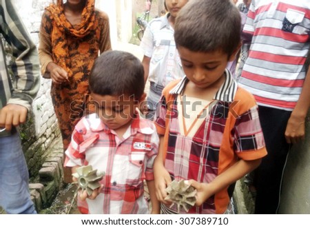 SIALKOT, PAKISTAN - AUG 18: innocent children are showing the shells of Indian mortar shells fired during today's unprovoked intensified heavy shelling by the Indian BSF on August 18, 2015 in Sialkot.