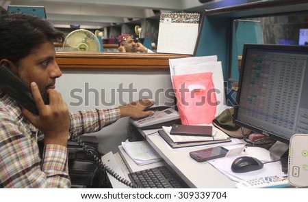 KARACHI, PAKISTAN - AUG 24: Trader busy in monitoring share prices as the KSE-100 \
Index went down 3.97%, or 1,370 points, to reach 33,149.6 points at 1:03 pm on August 24, 2015 in Karachi.