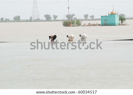 SUKKUR, PAKISTAN - AUG 27: Residents of Sultan Kot uses railway tracks to move towards a safe place after flood in the area of Sultan on August 27, 2010 in Sukkur.