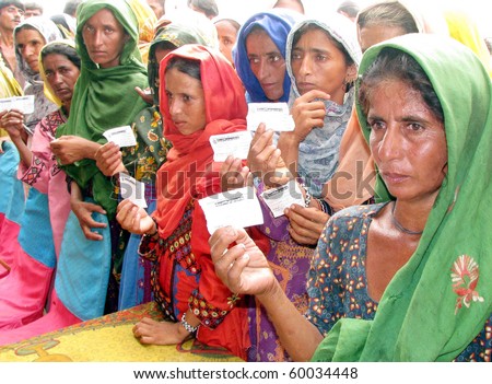 HYDERABAD, PAKISTAN - AUG 28: Flood affected women show their registration card during distribution of food bags at a relief camp on August 28, 2010 in Hyderabad.