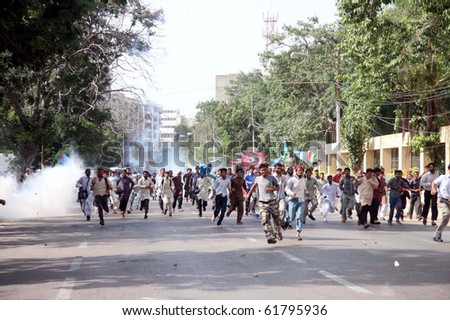 KARACHI- SEPT 24: Protesters run towards safe place after police officials fired tear gas shells to disperse them during protest demonstration of Islami Jamiat Talba Sept 24, 2010 in Karachi
