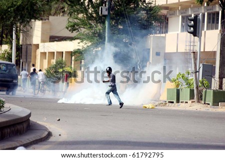 KARACHI- SEPT 24: Protesters run towards safe place after police officials fired tear gas shells to disperse them during protest demonstration of Islami Jamiat Talba Sept 24, 2010 in Karachi, Pakistan
