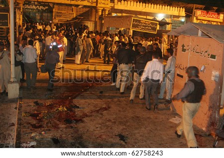 KARACHI, PAKISTAN - OCT 07: People gather at the site after two bomb explosions on October 07, 2010 in Karachi, Pakistan